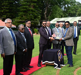 M Akshay Appaya presenting the M B Appaya trophy to trainer M Bobby after his ward won this event at Mysore on Thursday.