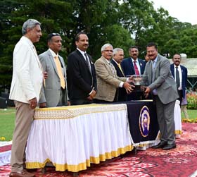 Steward of Mysore Race Club H K Ramesh presenting the Hyderabad Tace Club Trophy to trainer Pradeep Annaiah whose ward won the event at Mysore on Sunday.