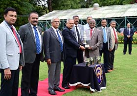 Mysore Race Club Chairman G Venkatesh presenting the Mysore Race Club Anniversary trophy M Ravi whose ward Shamrock won this event at Mysore on Saturday.