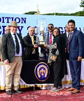 Mysore Race Club Chairman G Venkatesh presenting the Mysore Derby trophy to  Sharmila Padmanabhan whose ward Miracle Stat won this event at Mysore on Sunday.